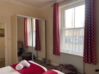 A bedroom with a bed and mirror at Mutiny House, Brewers Quay Harbour