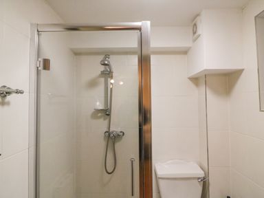 A bathroom with a glass shower enclosure and a toilet at The Oast House in Brewers Quay Harbour