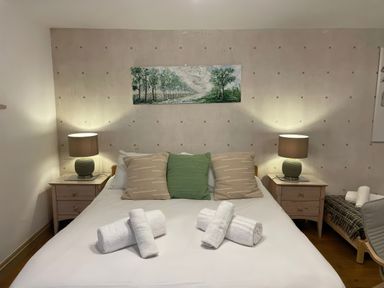 A bedroom with a bed, bedside table, and towels at The Oast House in Brewers Quay Harbour