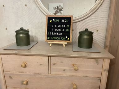 A dresser with a sign board and green containers at The Oast House in Brewers Quay Harbour