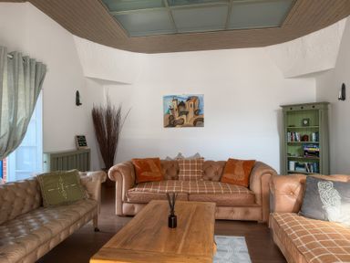 A living room with sofas, a coffee table, and a bookshelf at The Oast House in Brewers Quay Harbour
