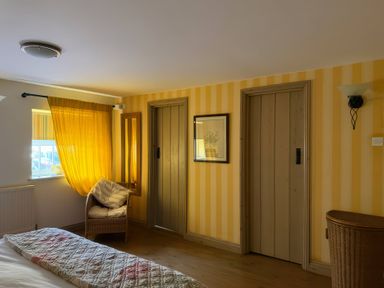 A bedroom with doors and a basket at The Oast House in Brewers Quay Harbour