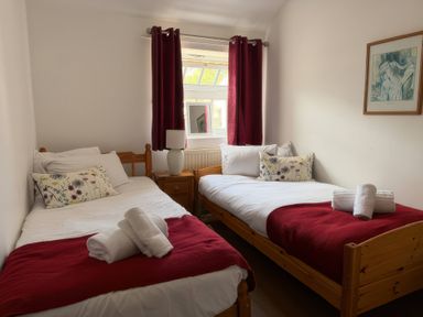 A bedroom with two single beds and a mirror at The Oast House in Brewers Quay Harbour