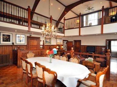 A dining room with a table and chairs under a chandelier next to a living area at The Old Portland Courthouse in Portland