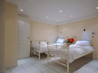 A bedroom with two single beds with white bedding and a door to the left at The Old Portland Courthouse in Portland