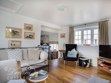 A sitting area with a metal framed sofa and black armchair near windows at The Old Reading Room in Langton Herring