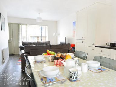 A dining table set with bowls mugs and fruit in a kitchen living room area at Olympic Cottage in Portland