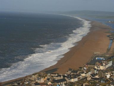 A coastal town with a long sandy beach and waves at Olympic Cottage in Portland
