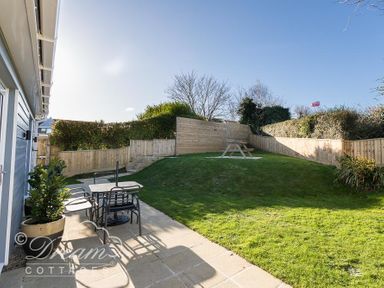 A garden with outdoor seating and a picnic table at Outlook Lodge in Bowleaze