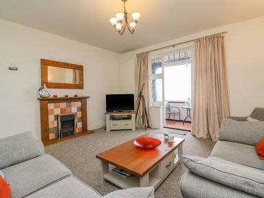 A living room with sofas a wooden coffee table a fireplace and a television at Ocean Watch 1 in Greenhill