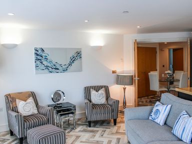A living room with armchairs and a coffee table at Estuary View in Kingsbridge