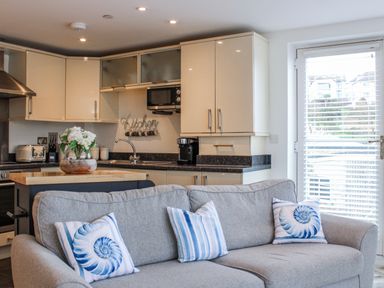A kitchen with a sofa and modern appliances at Estuary View in Kingsbridge
