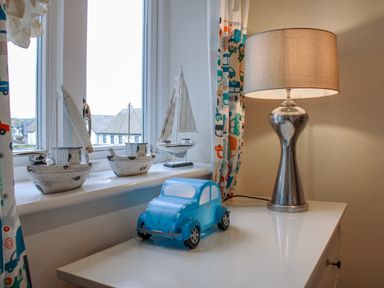 A bedroom with a toy car and model sailboats at Estuary View in Kingsbridge