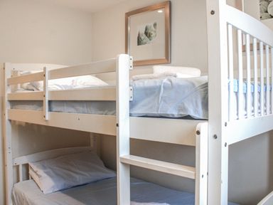 A bunk bed with white bedding at Estuary View in Kingsbridge