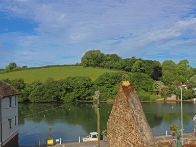 A view of water surrounded by trees and hills at Estuary View in Kingsbridge