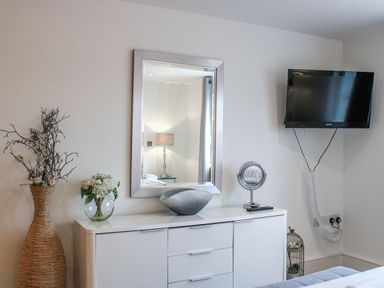 A bedroom with a television and dresser at Estuary View in Kingsbridge