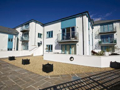 An outdoor area with modern buildings and planters at Estuary View in Kingsbridge