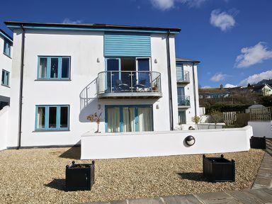 A building with a balcony and gravel area at Estuary View in Kingsbridge