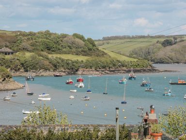 A river inlet with multiple boats anchored and green hills in the background at 14a Courtenay Street in Salcombe