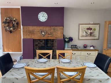 A dining room with a table set for four at Pedaller's Cottage in Weymouth