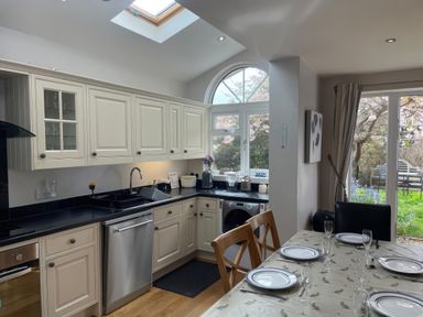 A kitchen with a dining table and chairs at Pedaller's Cottage in Weymouth