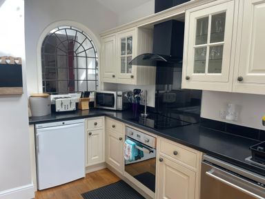 A kitchen with appliances and utensils at Pedaller's Cottage in Weymouth