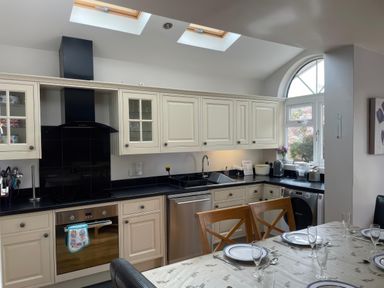 A kitchen with cabinets and appliances at Pedaller's Cottage in Weymouth