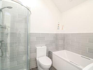 A bathroom with a shower cubicle toilet and bathtub at Poppies in Brewers Quay Harbour