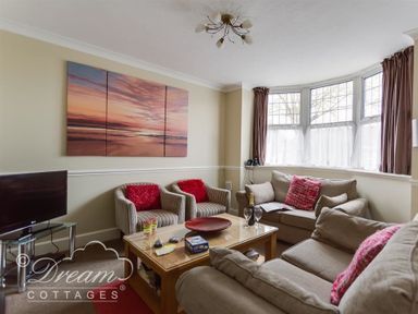 A living room with sofas armchairs a coffee table and a TV at Redcliff View Lodge in Weymouth