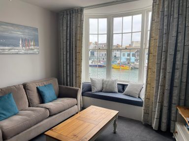A living room with a sofa and coffee table at Safe Harbour in Brewers Quay harbour