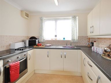 A kitchen with countertops microwave oven sink and cabinets at Sanjernin in Swanage