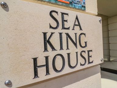 A stone sign with the text sea king house attached to a building wall at Cove Castle