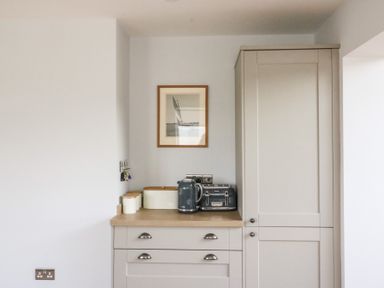 A kitchen counter with a kettle toaster and canisters under a framed picture at Shipton Hill View in Shipton Gorge