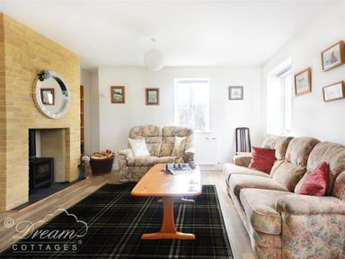 A living room with floral sofas a wooden coffee table a fireplace and framed pictures on walls at St Johns View in Portland