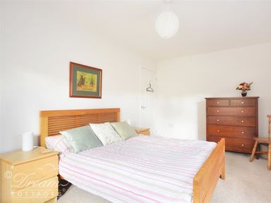 A bedroom with a wooden bed and nightstands a wooden dresser with flowers and a painting on the wall at St Johns View in Portland