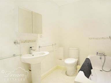 A bathroom with a sink mirror toilet and bathtub at St Johns View in Portland