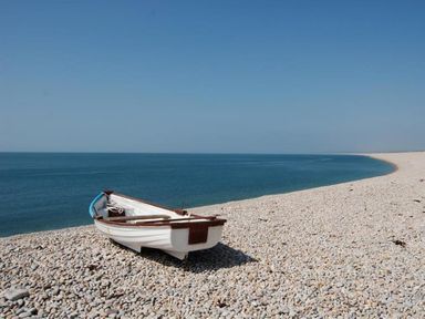 A small boat on a pebble beach by the sea at St Johns View in Portland