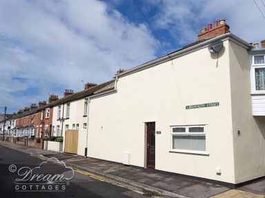 A row of terraced houses along a street with a street sign reading brownlow street at Sunny Days in Weymouth