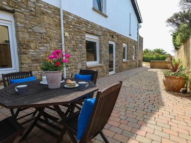 An outdoor area with a table and chairs at Tides Corner in Bowleaze