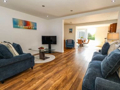 A living room with furniture and a view to the dining area at Tides Corner in Bowleaze