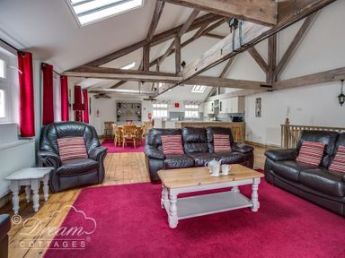 A living room with leather sofas coffee table dining table and wooden beams at Upsidedown House Brewers Quay Harbour