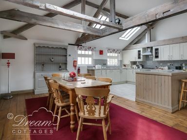 A kitchen and dining area with wooden beams and chairs at Upsidedown House Brewers Quay Harbour
