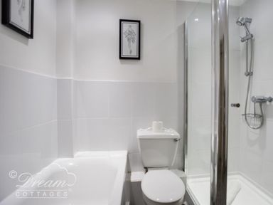 A bathroom with a bathtub toilet and glass shower enclosure at Upsidedown House Brewers Quay Harbour