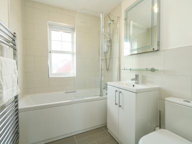 A bathroom with a bathtub shower combo sink vanity and toilet at Waters Edge in Wyke Regis