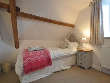 A bedroom with a single bed bedside table lamp and window at Warmwell Lodge in Warmwell