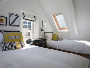 A bedroom with two single beds and bedside tables at 16 Courtenay Street in Salcombe