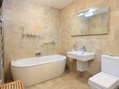 A bathroom with a bathtub sink toilet and mirror at 1 At The Beach in Torcross