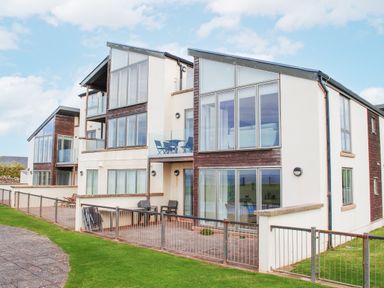 A building with balconies and grass at 2 Ocean's Edge Thurlestone