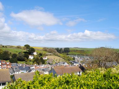 A village with houses and greenery under a blue sky at 2 Rockmount in Salcombe