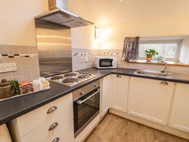 A kitchen with a stove oven microwave sink and countertop at Y Bwthyn in Elidir Fach Mountain near Llanberis